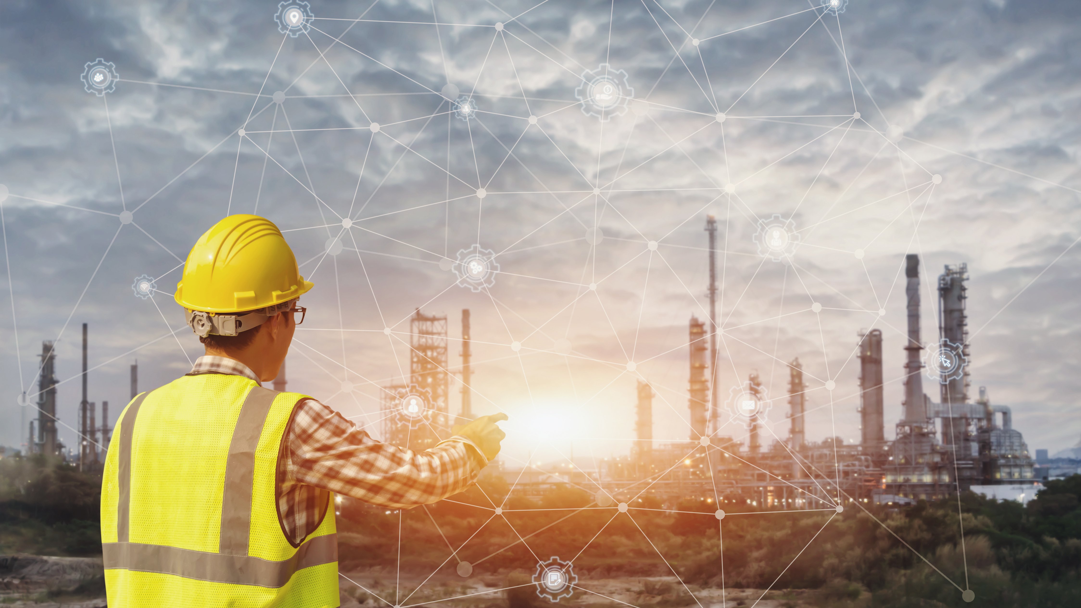 Un hombre de negocios con casco de seguridad que toca una pantalla de interface virtual como concepto de la industria