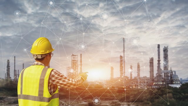 Un hombre de negocios con casco de seguridad que toca una pantalla de interface virtual como concepto de la industria